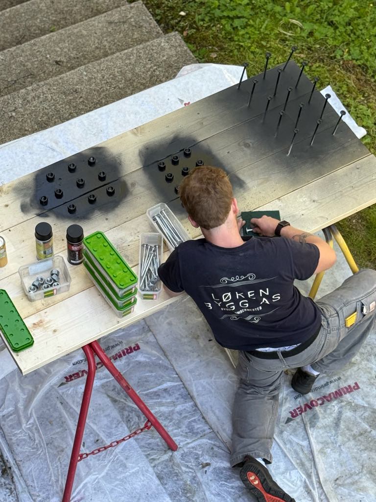 Gutt lakker skruer og bolter til nytt vannhjul på Teknisk museum